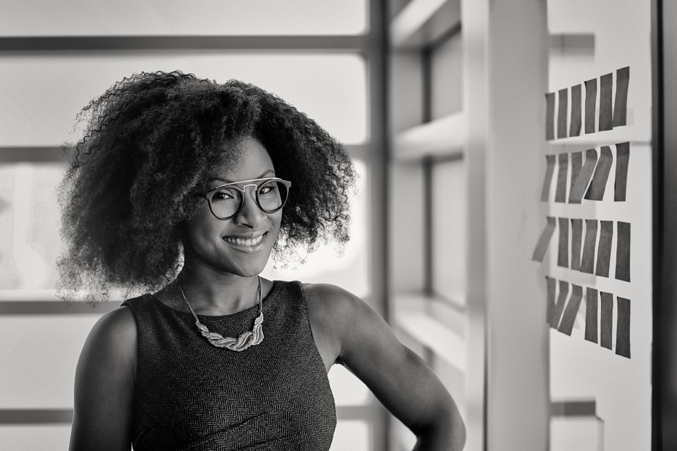 Portrait of a smiling business woman with an afro in bright glass office