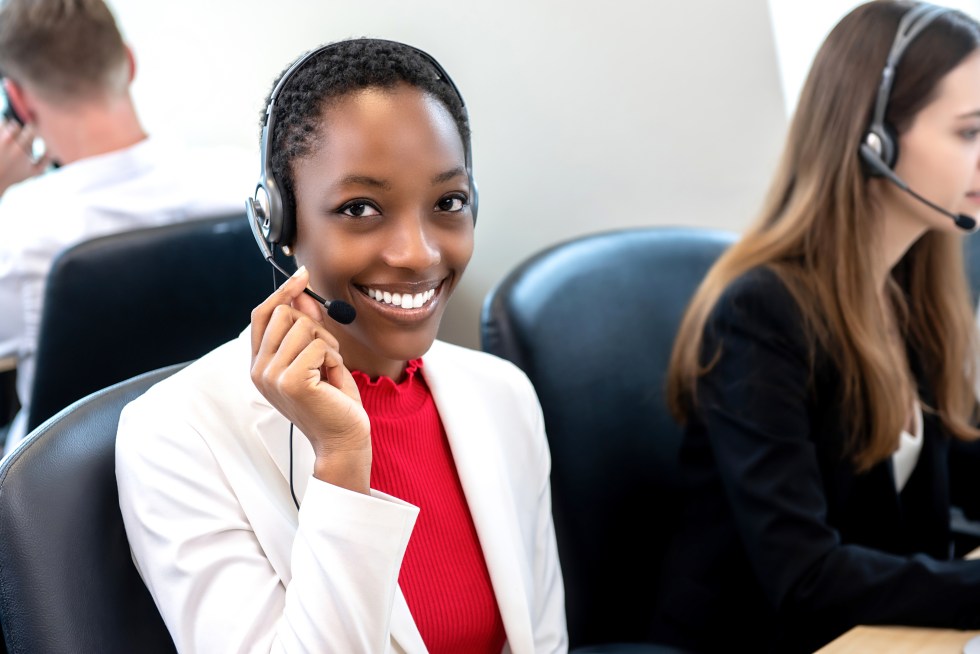 Smiling beautiful African American woman working in call center with diverse team